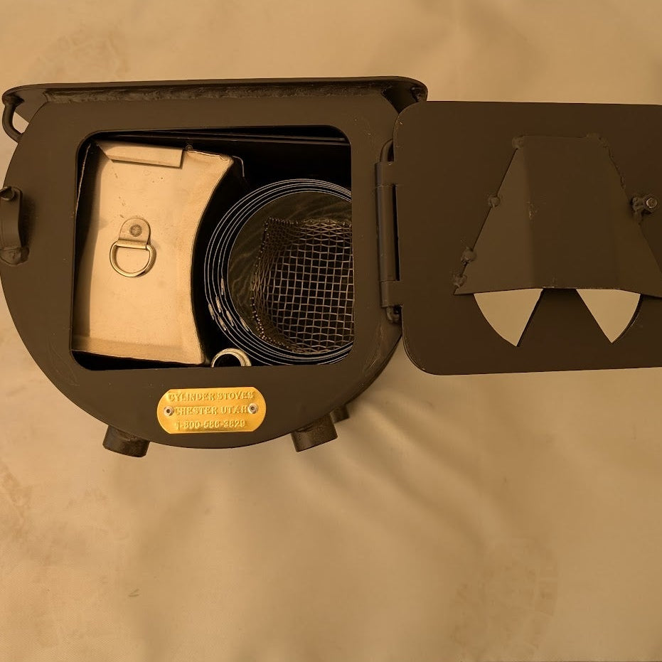 Front view of a tent stove with its door open, showing a water heater, coiled stove pipe, and mesh spark arrestor stored inside.