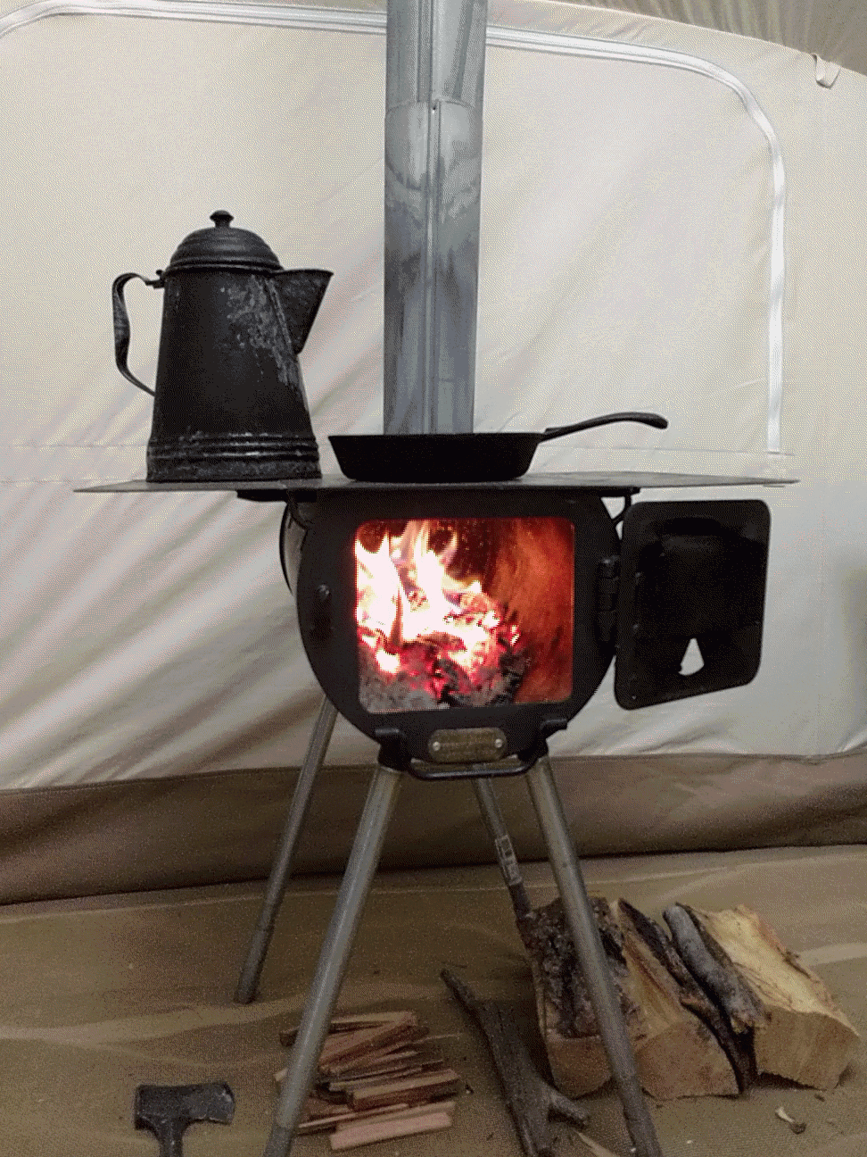 comforting warm stove with A fire in it set up in a roamin home camping tent